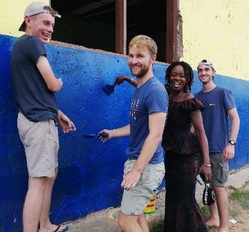 Rémi peint avec des membres de l'association qu'il accompagne au ghana