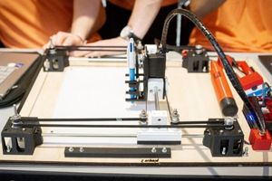 gros plan sur un système robotisé qui tient un stylo dessinant sur une feuille