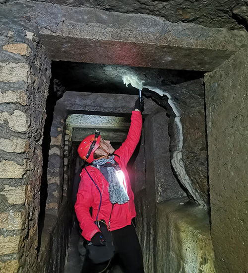 Géologue observation une concrétion de calcite à l'intérieur du Spéléodrome
